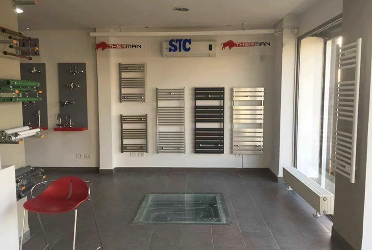 Showroom avec sèche-serviettes Therman en acier, noir et inox, exposés sur un mur